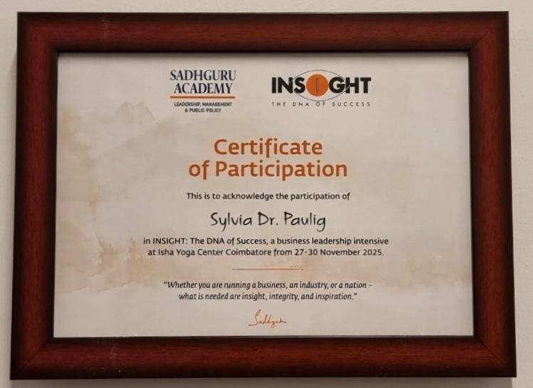 Teilnahmezertifikat von Sylvia Dr Paulig mit braunem Holzrahmen und Logos in Farbe